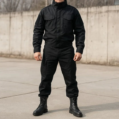 Homme habillé tout en noir portant des rangers chaussures de combat sur un sol en béton, illustrant leur usage en milieu urbain tactique