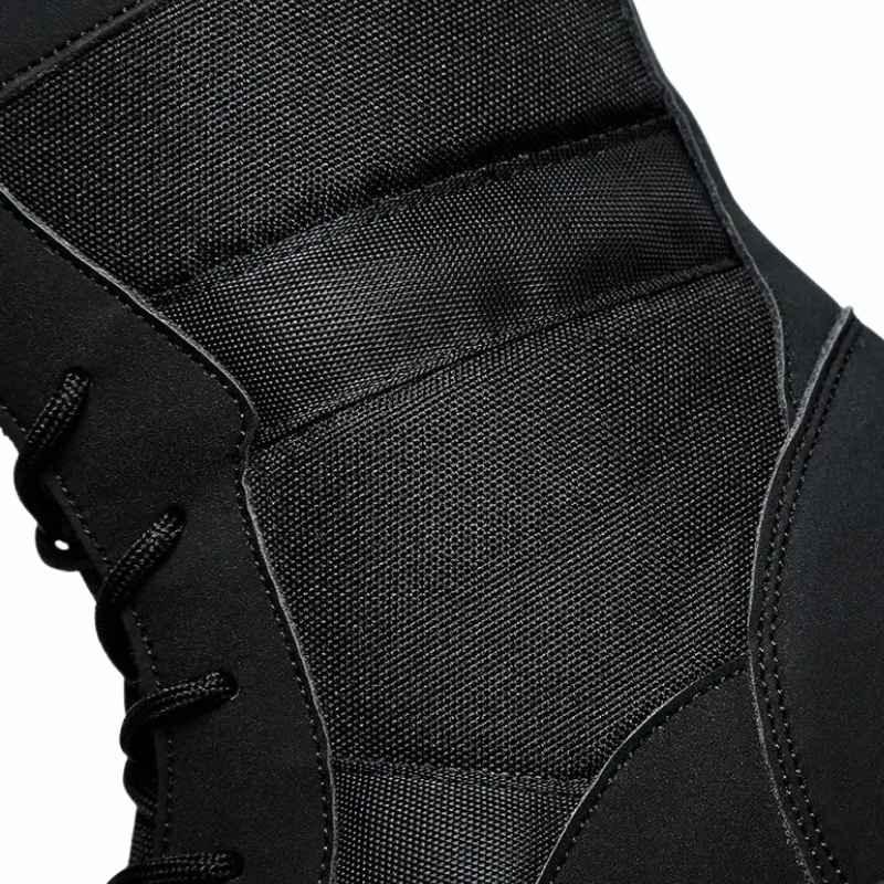 Gros plan sur le tissu renforcé des rangers militaires tactiques noires avec surpiqûres visibles