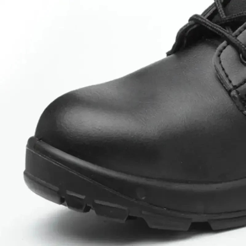 Gros plan sur l’embout renforcé d’une chaussure rangers coquée noire, mettant en évidence la coque de protection intégrée pour absorber les chocs