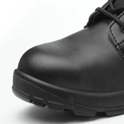Gros plan sur l’embout renforcé d’une chaussure rangers coquée noire, mettant en évidence la coque de protection intégrée pour absorber les chocs