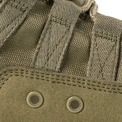 Gros plan sur le tissu des chaussures rangers commando vertes avec focus sur deux trous d’aération, assurant respirabilité et confort en conditions extrêmes